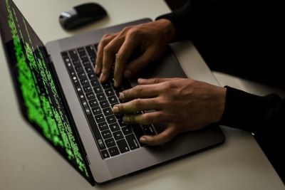 two hands typing on a computer