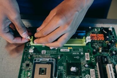 hands working on a circuit-board