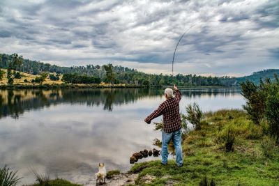 person casting a fishing line into a river